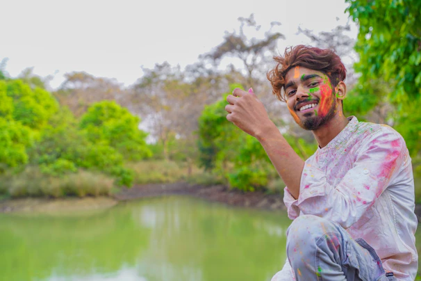 A serene moment of a child smiling with a face painted in multiple Holi colors.