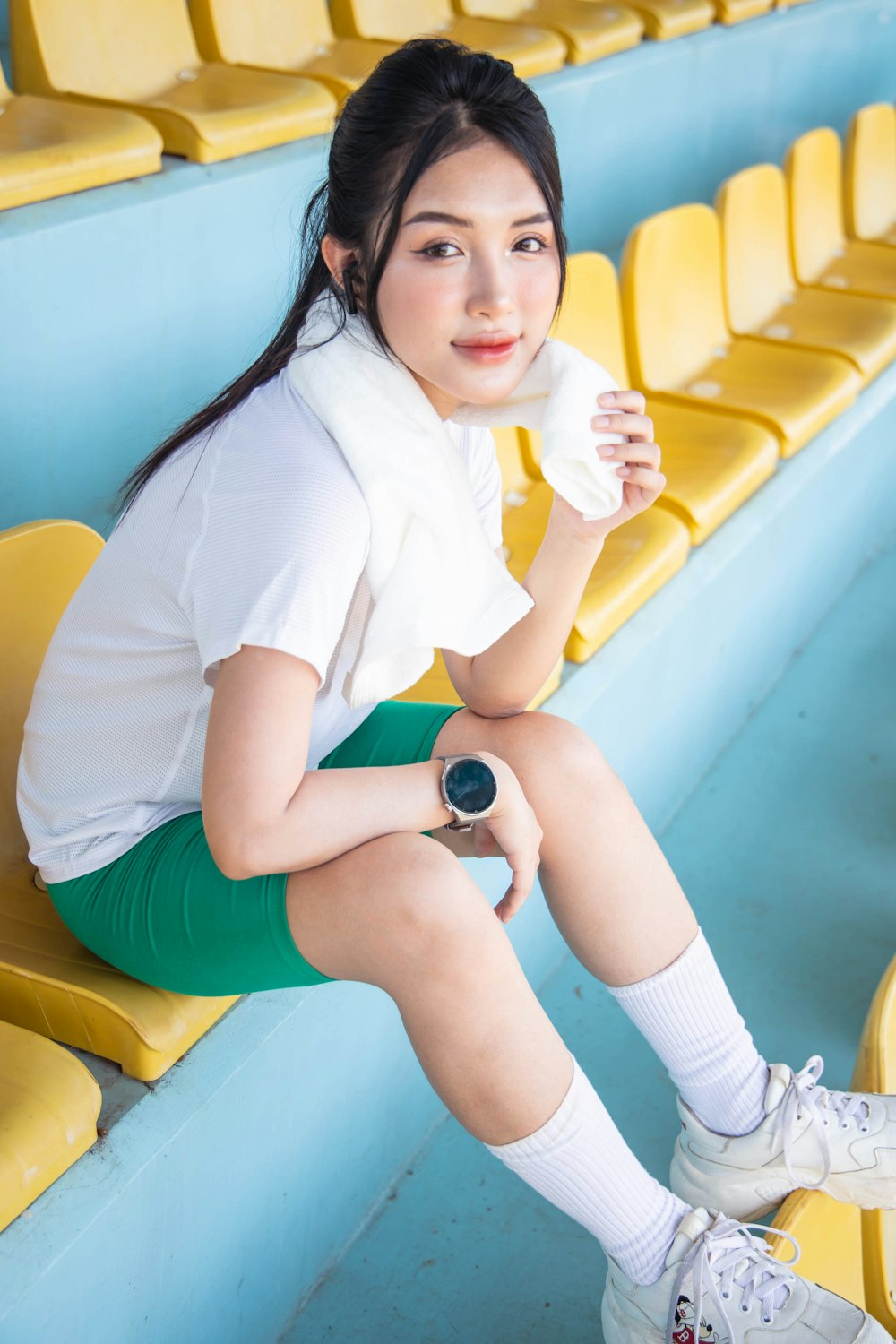 a woman sitting on a bench in a stadium