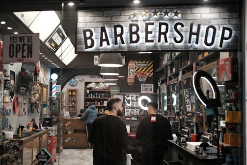 a barber shop with two men standing in front of it