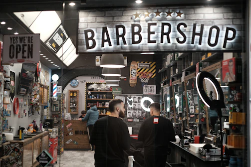 a barber shop with two men standing in front of it