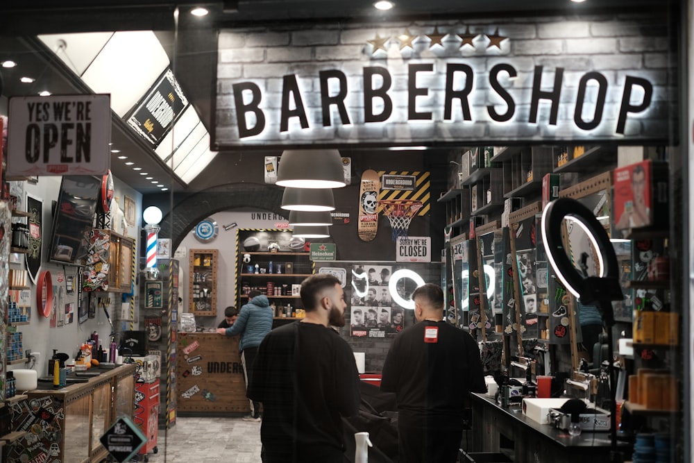a barber shop with two men standing in front of it