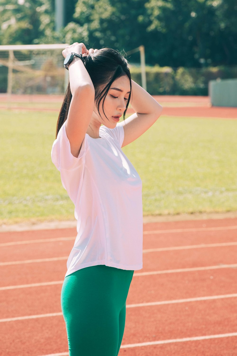 a woman standing on a tennis court holding her head