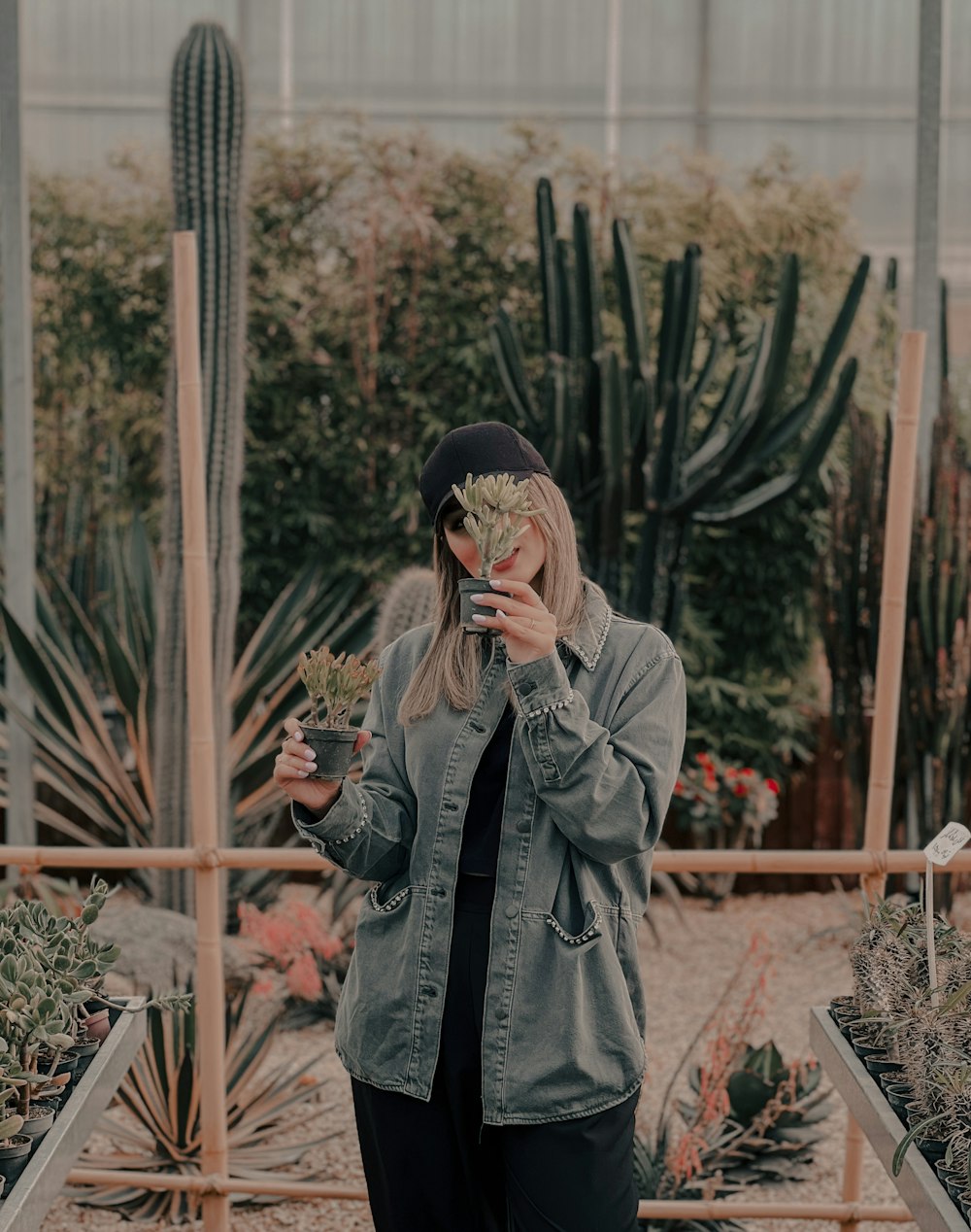 a woman taking a picture of herself in a greenhouse