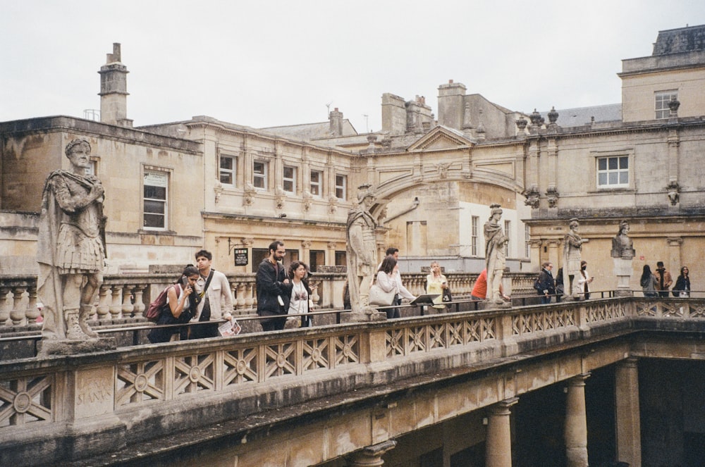 a group of people walking across a bridge