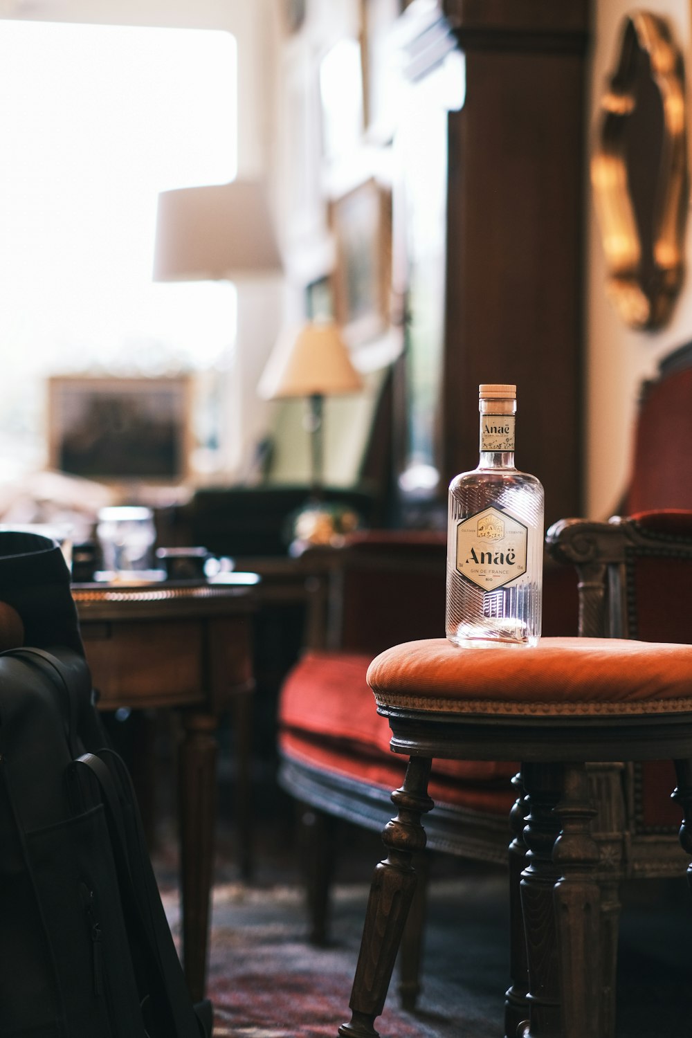 uma garrafa de vodka sentada em uma cadeira em uma sala de estar