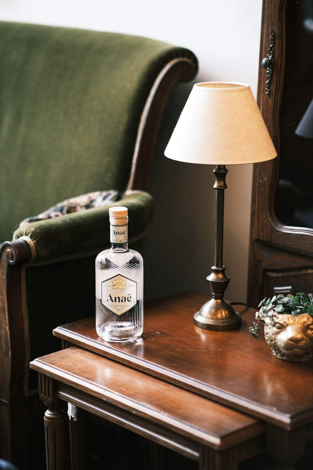 a bottle of alcohol sitting on a table next to a lamp