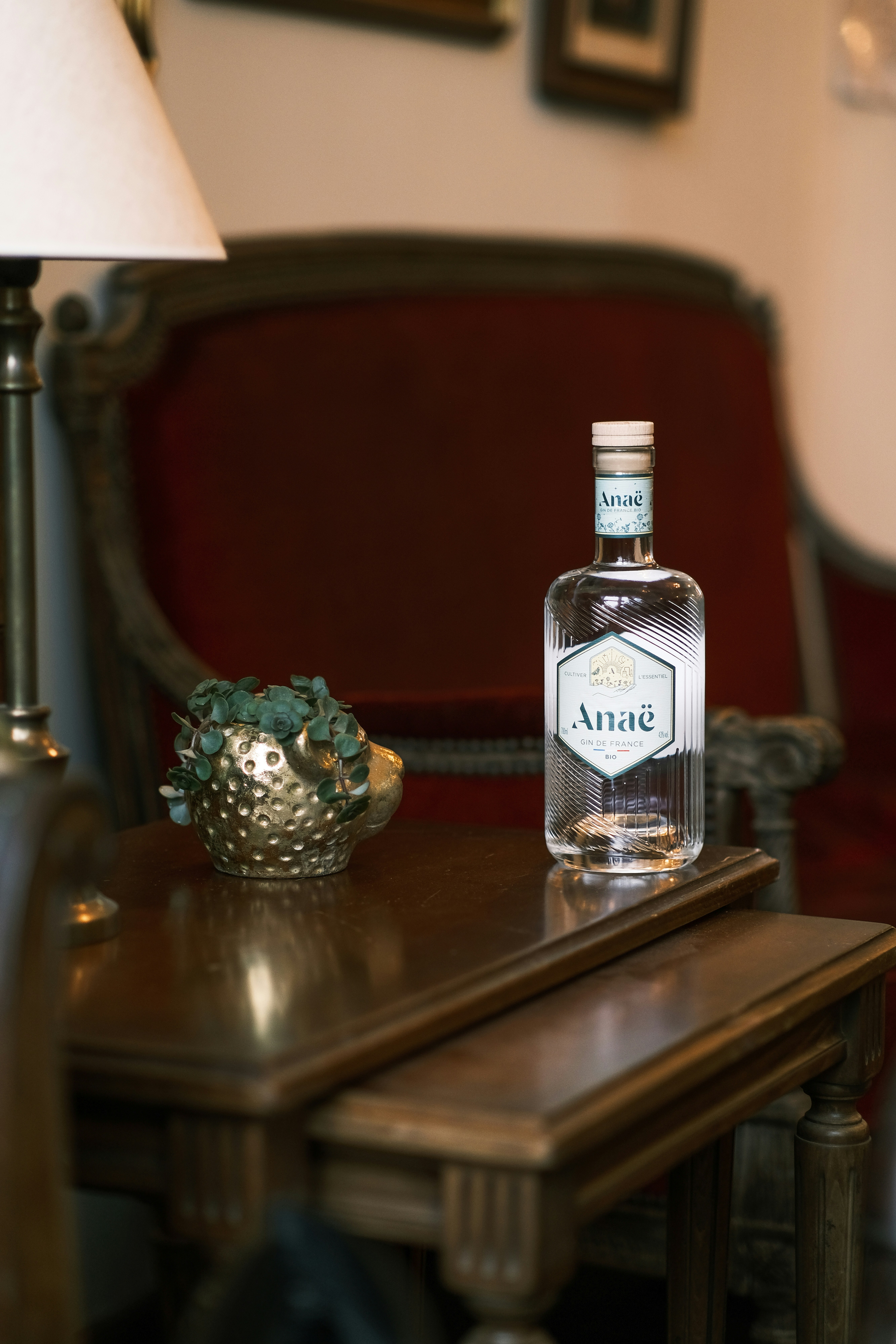 une bouteille d’alcool posée sur une table à côté d’une lampe