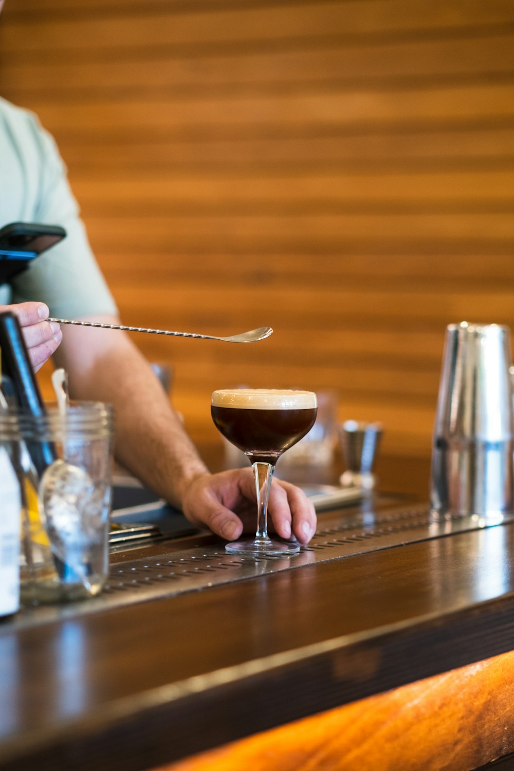 a man sitting at a bar with a drink in front of him