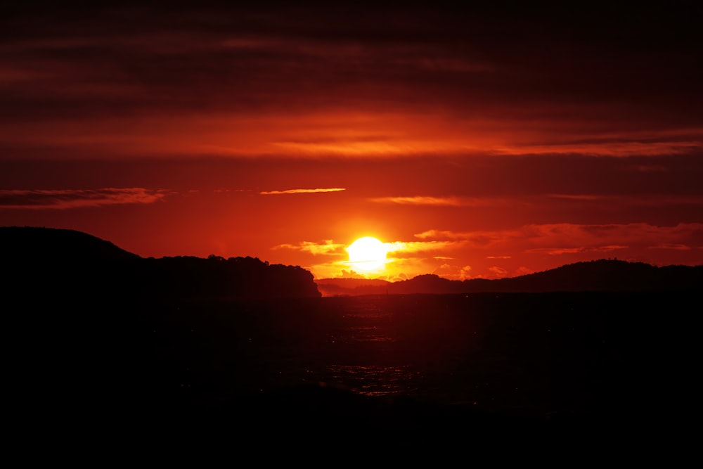 the sun is setting over a mountain range