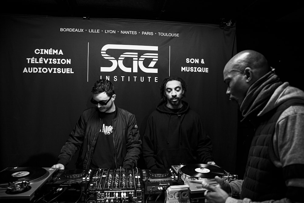 three men in masks are at a dj booth