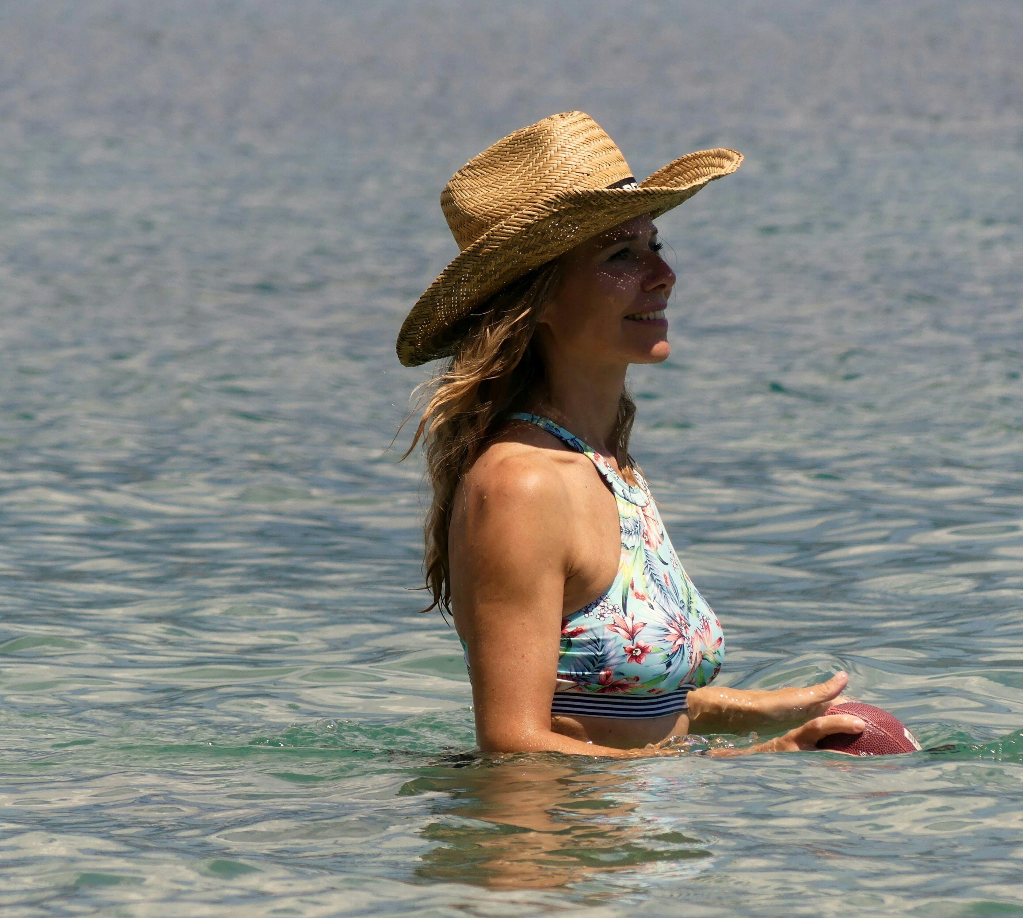 a woman in a hat is in the water