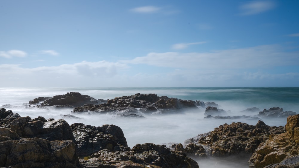 a view of a rocky beach with the ocean in the background