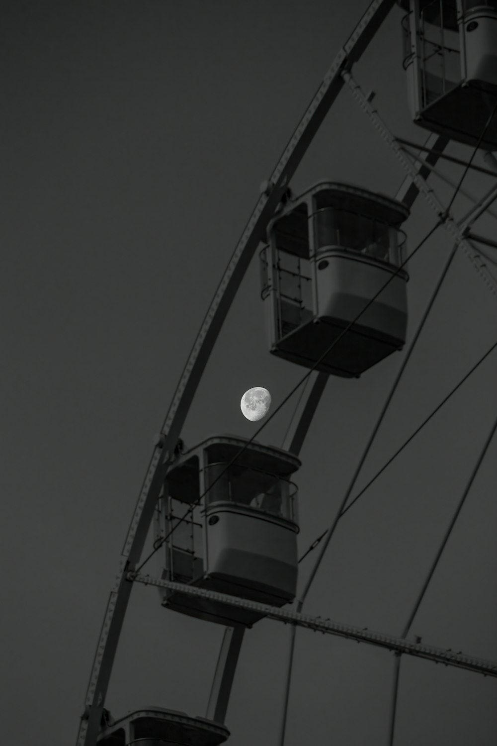 a ferris wheel with a full moon in the background