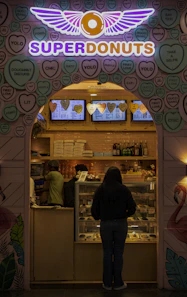 a woman standing in front of a doughnut shop