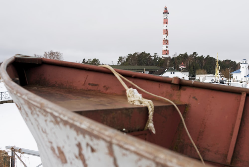 a rusted boat with a lighthouse in the background