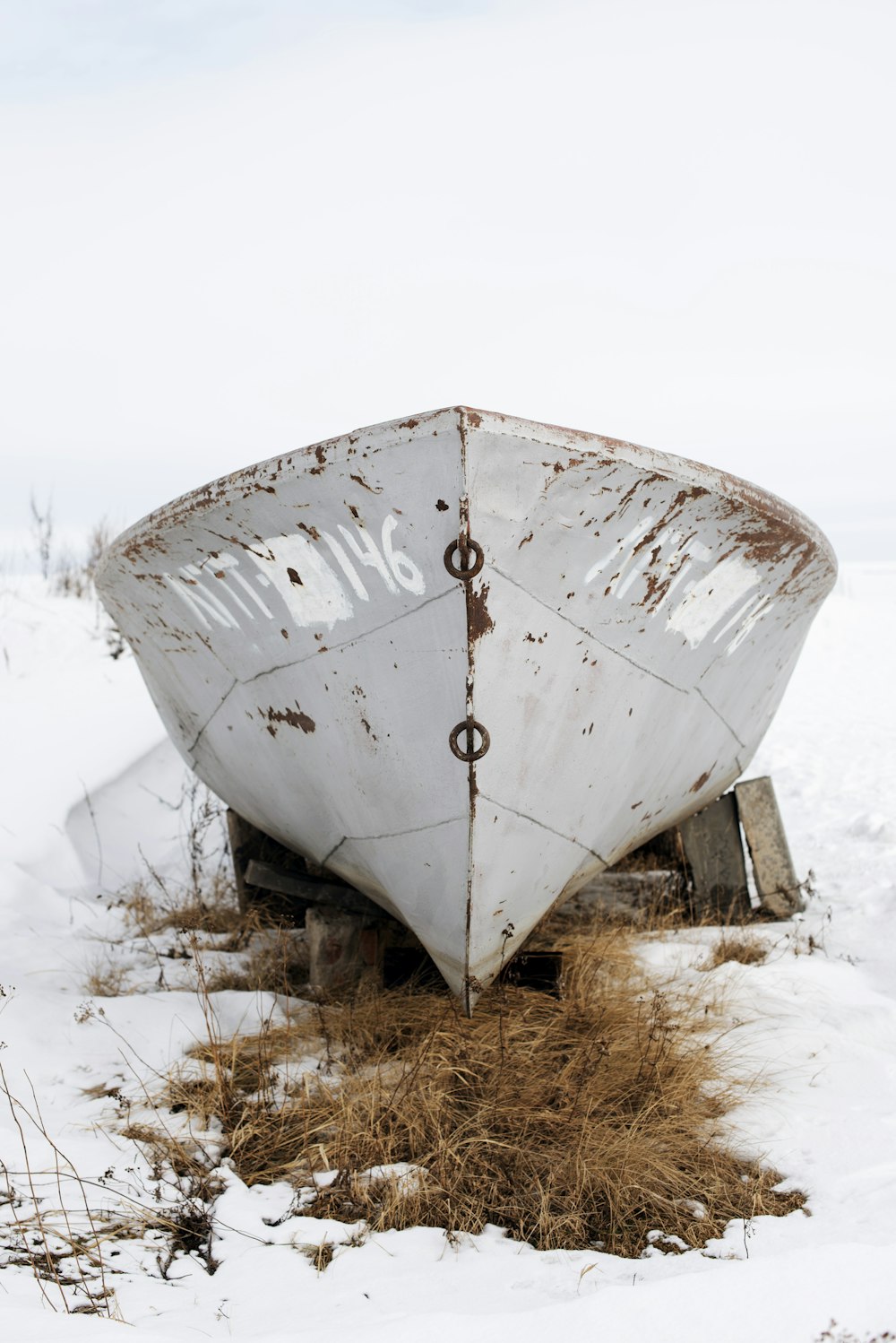 a white boat sitting on top of snow covered ground