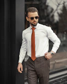 A stylish man wearing a premium tailored shirt, standing confidently in an urban setting.