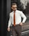 A well-dressed man in a stylish outfit standing confidently in an urban setting.