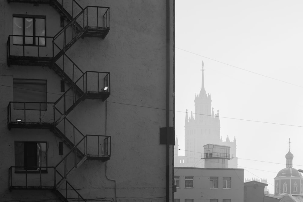 a black and white photo of a building with a steeple in the background