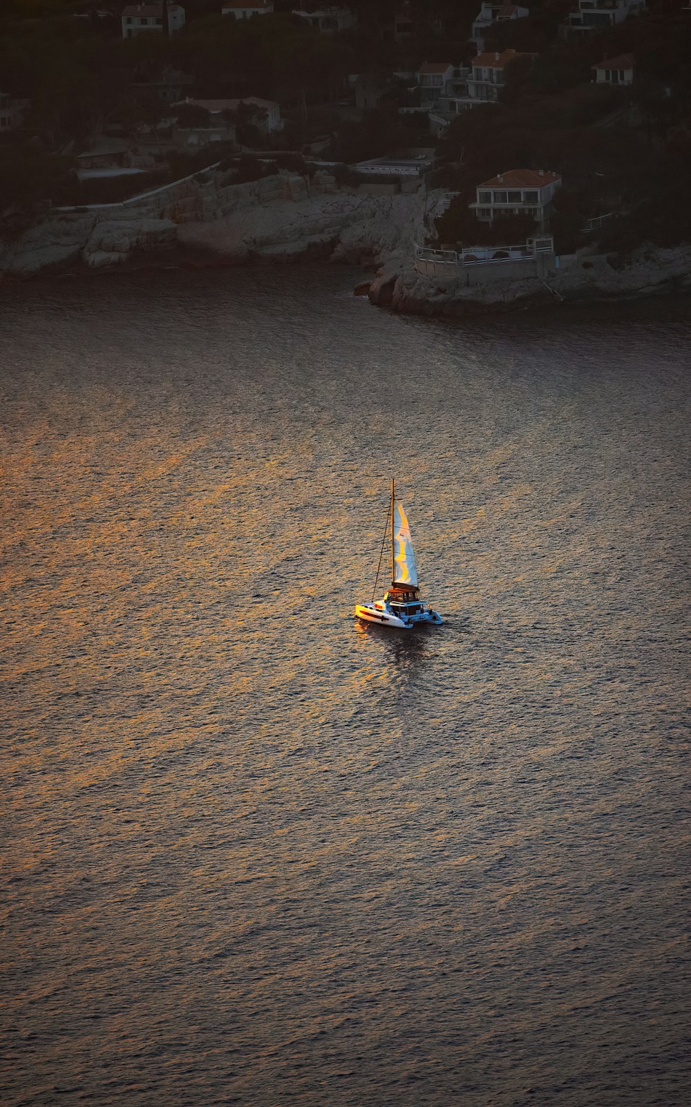 a small sailboat floating on top of a body of water