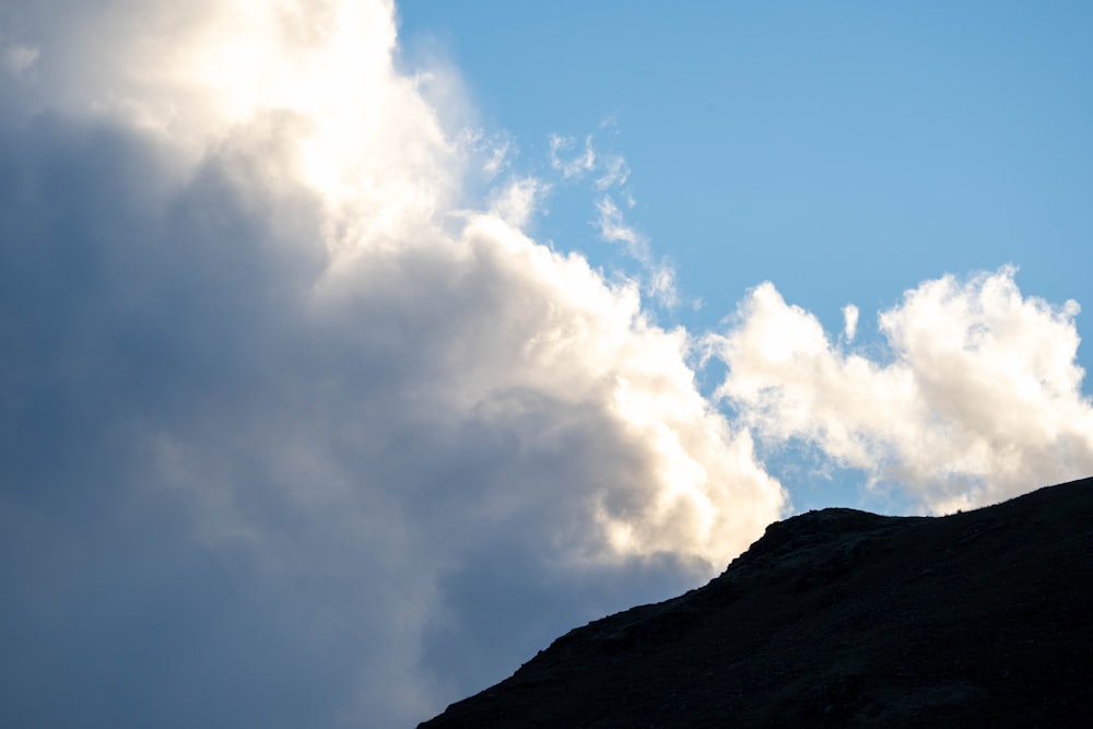 a bird flying in the sky above a mountain