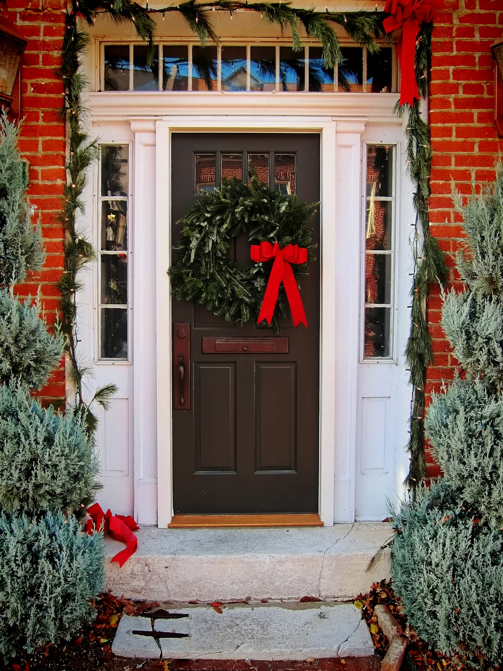 a door with a wreath and a red bow on it
