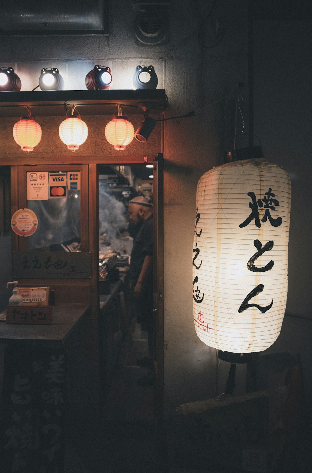 a person standing in a room with a lantern