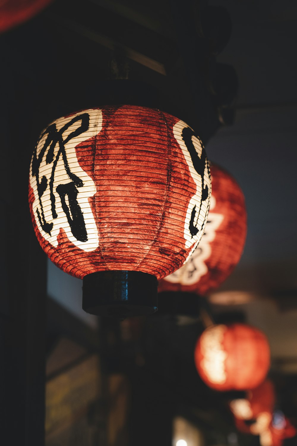 a couple of red lanterns hanging from a ceiling