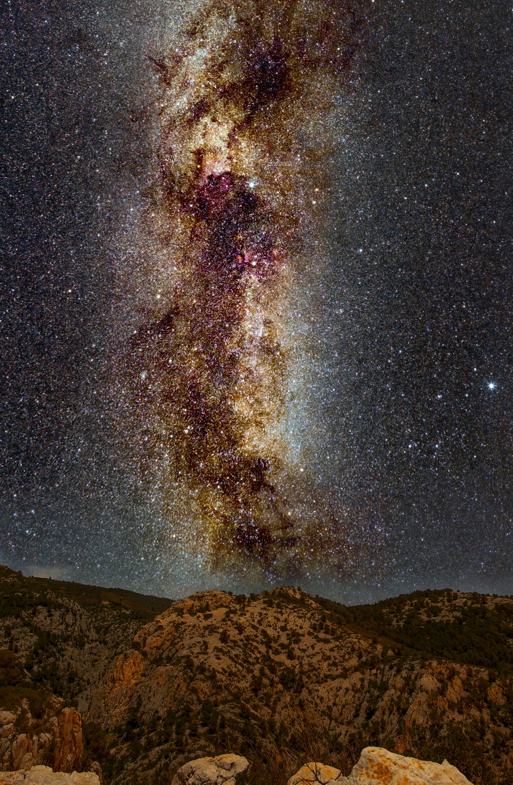 a view of the night sky from a rocky outcropping