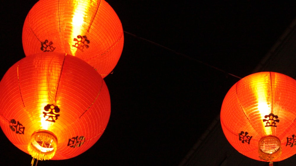 three red lanterns lit up in the dark