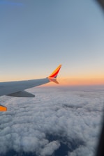 the wing of an airplane flying above the clouds