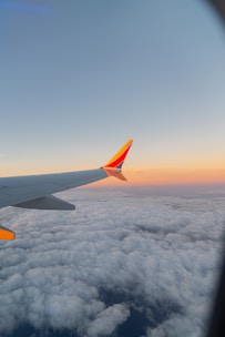 the wing of an airplane flying above the clouds