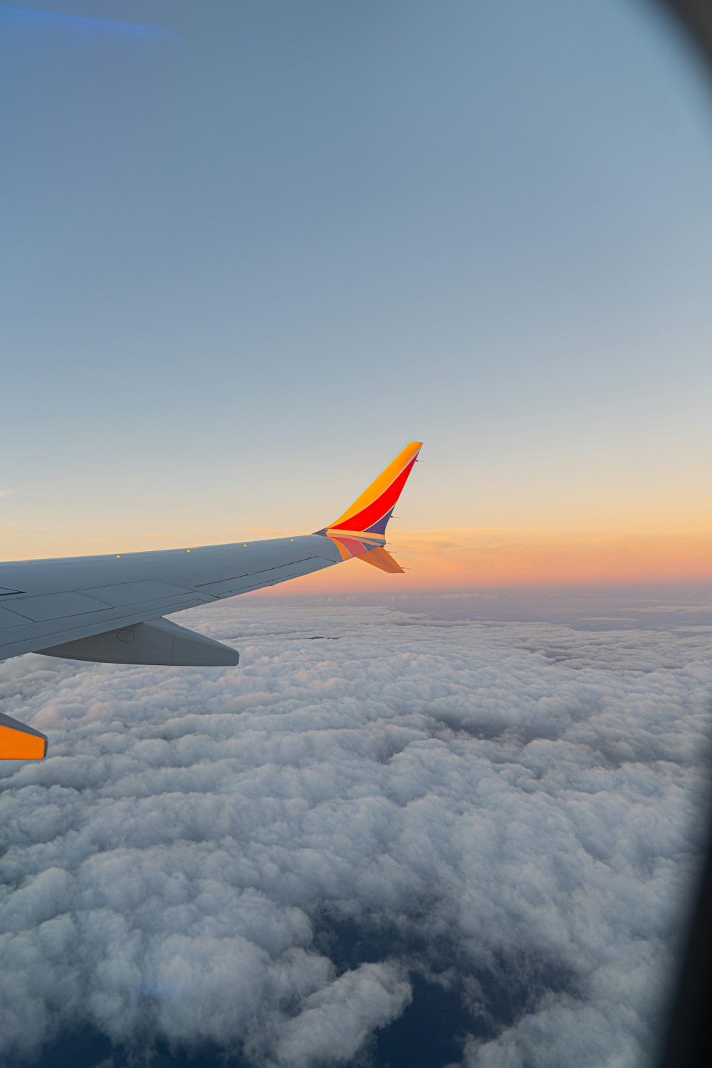 the wing of an airplane flying above the clouds