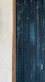 Close-up of a feature wall painted in a deep teal with perfect edges and smooth texture.