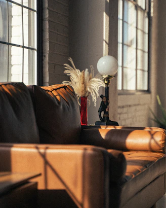 A cozy living room with sunlight streaming in, featuring an automatic spray dispenser releasing a gentle mist.