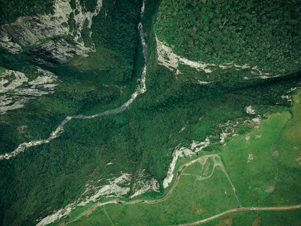 an aerial view of a river running through a lush green valley