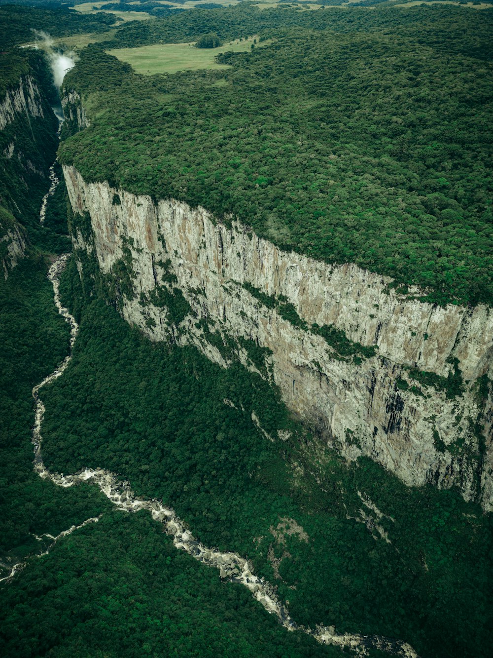 an aerial view of a cliff with a river running through it