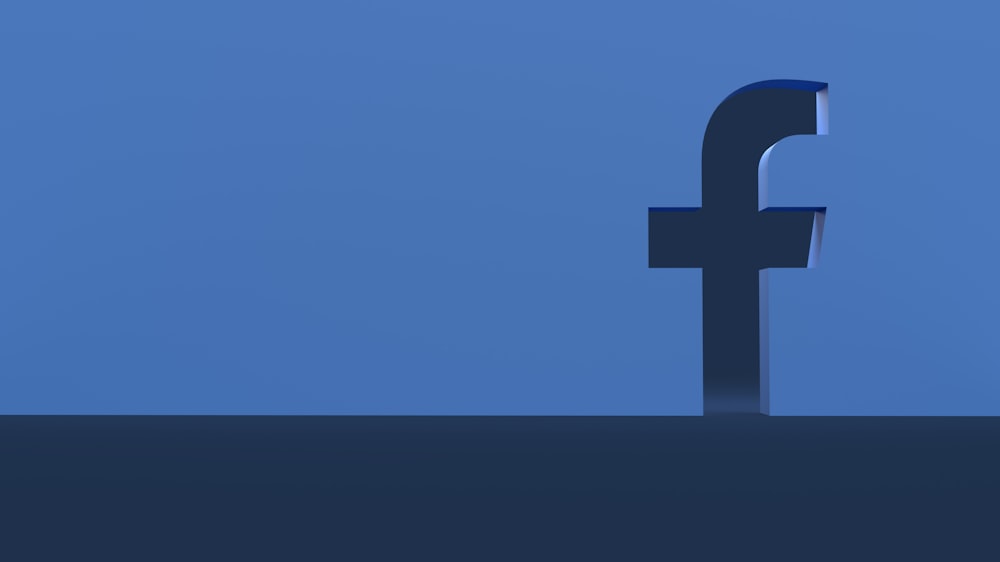 Une personne debout devant un logo Facebook
