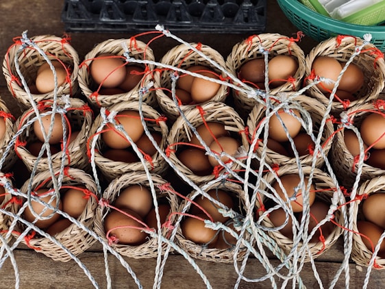 Close-up of a basket filled with fresh organic brown eggs nestled in straw.