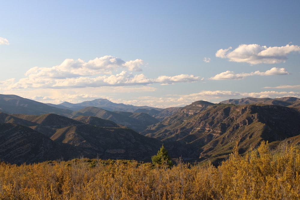 a view of a mountain range with a few clouds in the sky