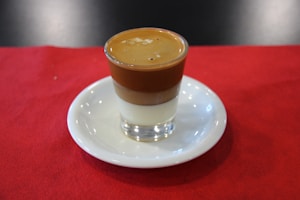 a cup of coffee sitting on top of a white saucer
