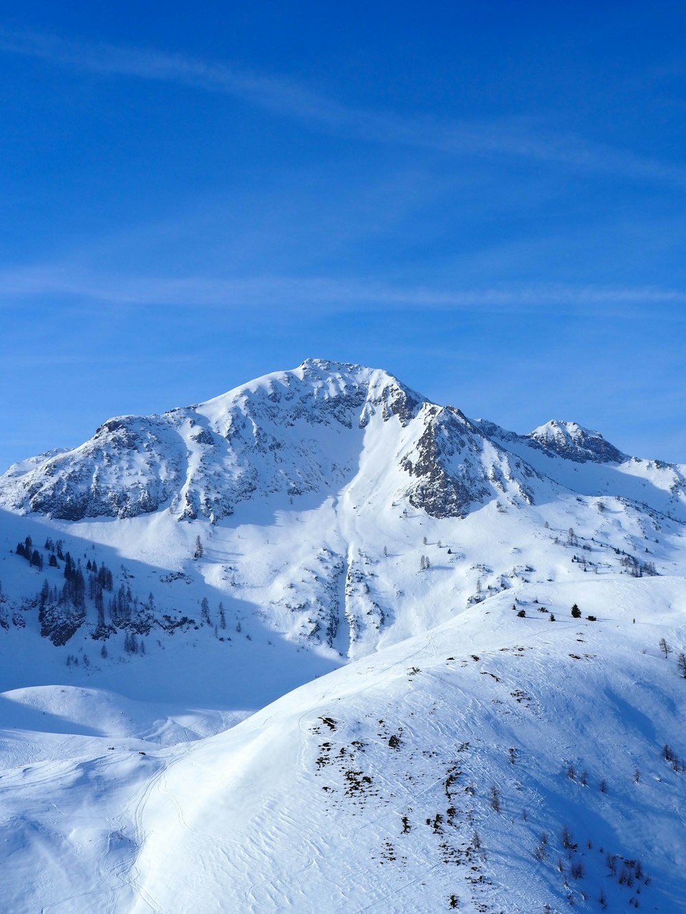 a mountain covered in snow under a blue sky