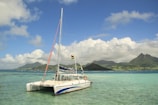 a sailboat in the water with mountains in the background