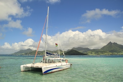a sailboat in the water with mountains in the background