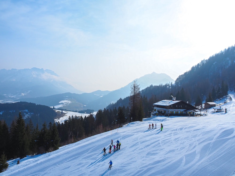 a group of people riding skis down a snow covered slope