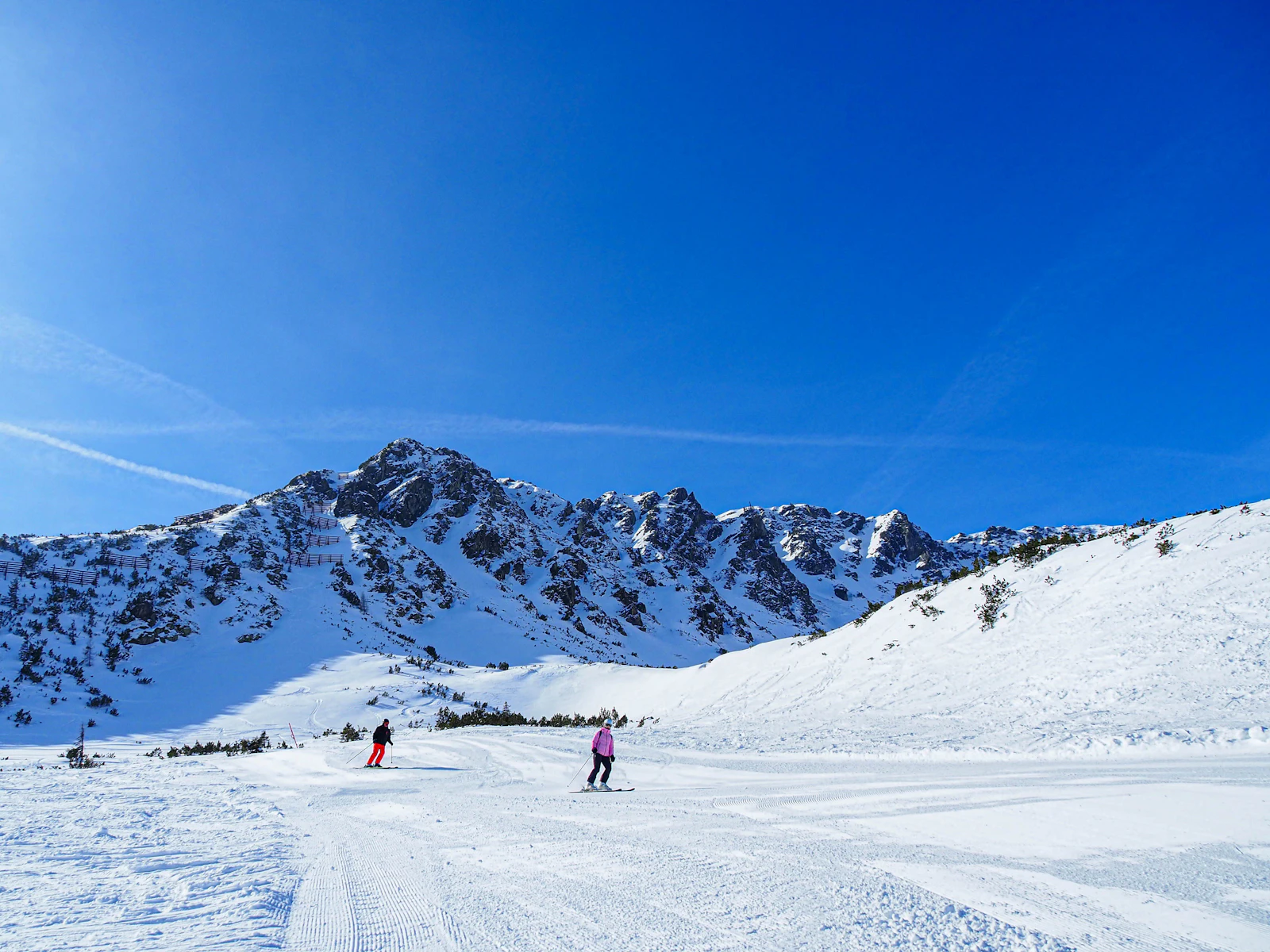Snow-covered Alpine mountains and ski slopes on a sunny winter day