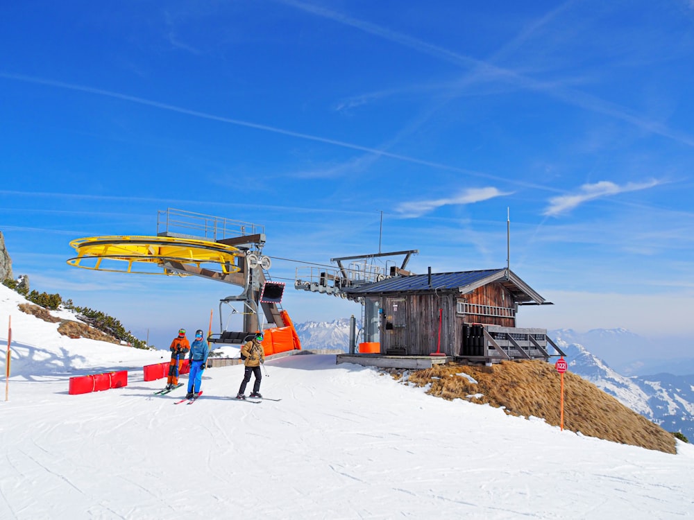 a couple of people standing on top of a snow covered slope