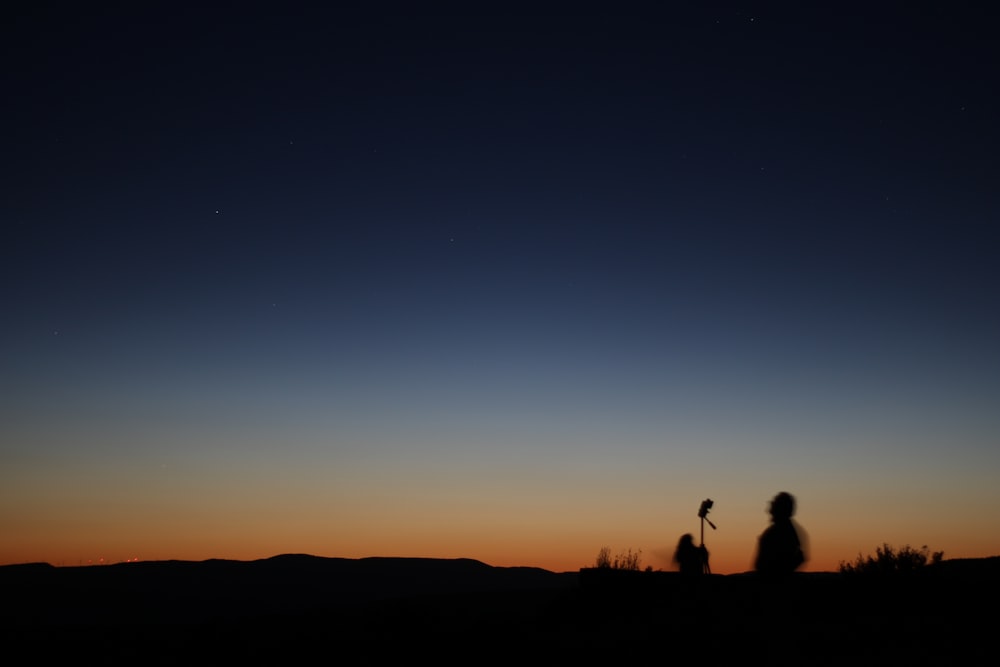 a couple of people standing on top of a hill