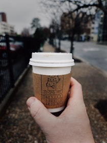 A drone delivering a coffee cup to a customer.