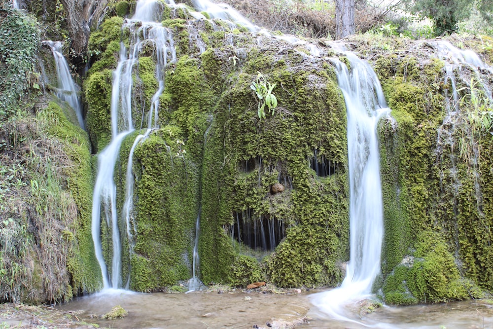 a waterfall with moss growing on the side of it